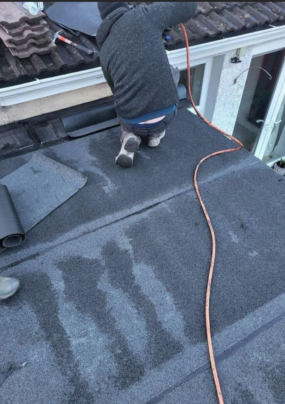 Torch-on felt being laid on a flat roof