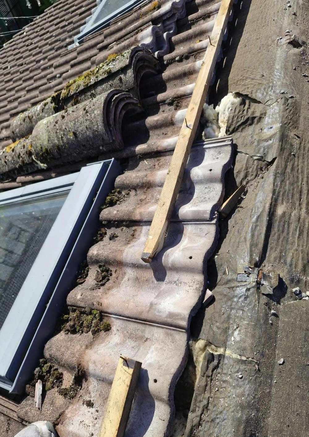 Tiles lifted around a rooflight to trace a leak